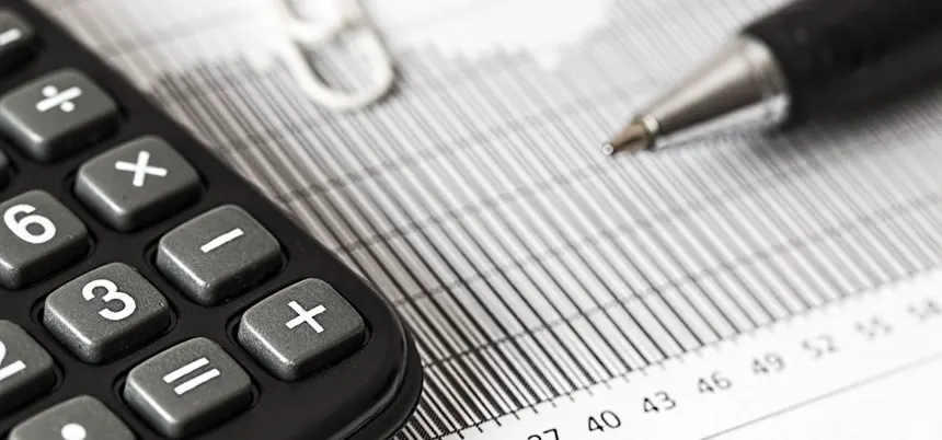 Calculadora y pluma sobre una tabla de cifras
